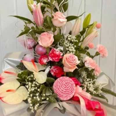 Pink Frost - This flower box arrangement is part of our Luxury Christmas range. Bursting with pink candy cane decorations, lillies, roses, carnations, anthuriums & foliage.