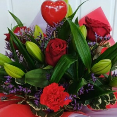 Happy Valentine's - A beautiful flower box arranged in oasis and presented with cellophane, box & a heart. The flowers include red roses, lillies, carnations & statice in red, purple & whites.