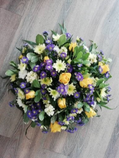 Posy Pad - Yellow & Purple - A Posy pad with a mixture of flowers in Yellows & Purples. This tribute will contain roses and a mixture of other flowers and foliages.

A beautiful tribute for a lady or gentlemen.