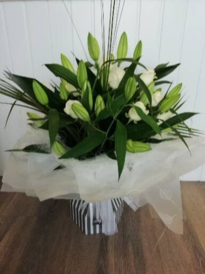 White Lillies & Roses - This ultra modern handtied arrangements comes complete in its very own water tight box vase. This arrangement will include white lillies, white roses and a mixture of foliages, finished off with a soft organza bow and a butterfly. 

Just simply divine & is a WOW for any occasion.