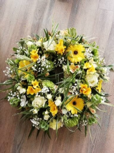 Wreath - Yellow, White & Green - A traditional wreath with a mixture of flowers in Yellows, Whites & Greens. This tribute will contain roses, gerbera and a mixture of other flowers and foliages.

An elegant tribute for a lady or gentlemen.

Product shown is the medium.