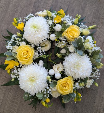 Wreath - Yellow, White & Green - A traditional wreath with a mixture of flowers in Yellows, Whites & Greens. This tribute will contain roses, gerbera and a mixture of other flowers and foliages.

An elegant tribute for a lady or gentlemen.

Product shown is the medium.