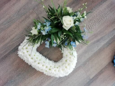 Based Open Heart - White & Sky blue - A open heart tribute massed in white double chrysanthemums with a side cluster of white & sky blue flowers.