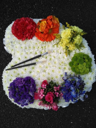 Artist Palett - A large funeral tribute for a person who loves Art. A number of different colour clusters on an artist palett design. Finished off with 2 paint brushes.