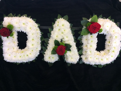 DAD - Red Roses - A DAD tribute in striking red and white. Letters based in white chrysanthenums with a foliage edge. Naomi luxury red rose and foliage clusters to compliment the design.