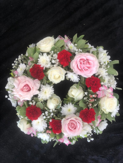Wreath - Red & Pink - A round traditional wreath in Red, Pale pink & White; filled with seasonal flowers & foliages.