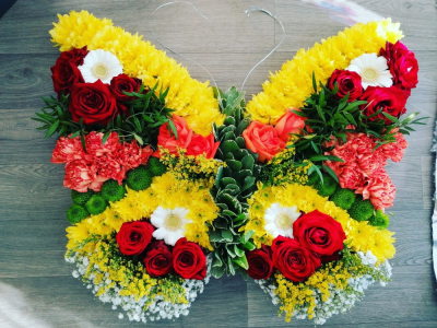 Autumnal Butterfly - A beautiful Butterfly tribute in 2 different sizes. This tribute inlcudes a number of different colours, flowers and foliage.

Image shown is the Deluxe size