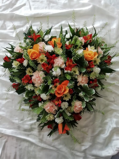 Heart - Orange, Peaches & Creams - A Heart floral tribute with a mixture of seasonal flowers & foliages including Roses in Orange, Peaches & Creams.