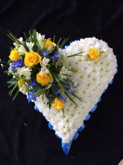Based Heart - Yellow, Blue & White - A beautiful heart tribute. Edged with blue ribbon, massed in White Chrysanthemum and a cluster of Yellow Roses & a mixure of blue and white flowers & foliages