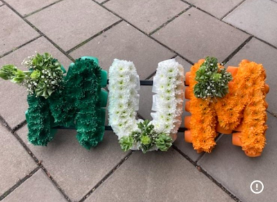 Green, white and gold mum letters - A mum in green , white and gold letters with bells of Ireland (mollucella) in each cluster
