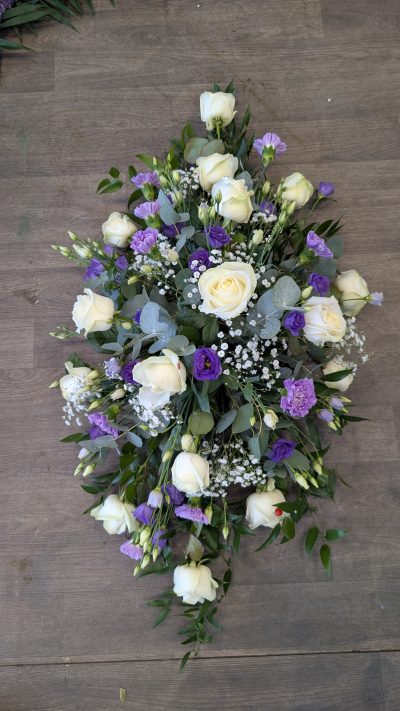 Casket Spray - Purple & White - A purple & white casket spray filled with a mixture of seasonal flowers & foliages