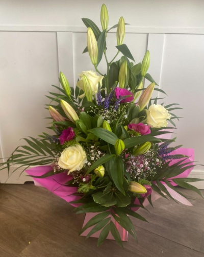 Mia - A front facing arrangement in a flower box filled with Pink, purple & white flowers to include lillies & roses