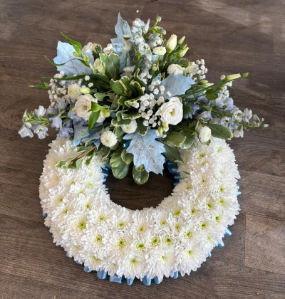 Blue Massed Wreath - A beautiful wreath designed with a pale blue ribbon edge, white based chrysanthemums & a pale blue and white spray