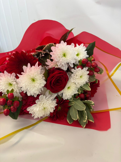 Mabel - A beautiful bouquet in reds & whites; wrapped in rich red cellophane, a gorgeous bow & some cones.