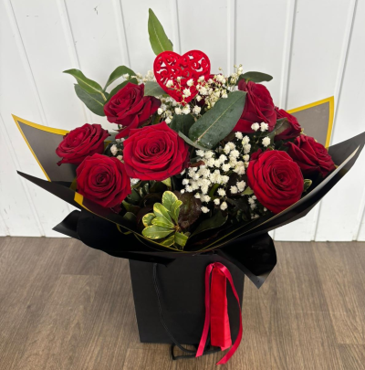 Dozen Roses - 12 luxury red Naomi roses, gypsophila & greenery arranged as a hand tied arrangement in water. Wrapped elegantly and finished off with a satin bow & heart